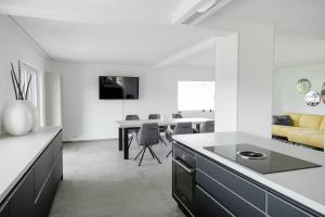 a kitchen with white walls and a dining room at Einzigartiges Loft von Loftalive in Lollar