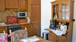 a kitchen with wooden cabinets and a table with a microwave at Ferienwohnung Heidi in Altena