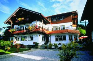 una grande casa bianca con balconi e fiori di Landhaus Kaiserblick a Ellmau