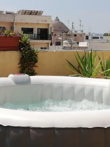eine Badewanne mit Wasser auf dem Balkon in der Unterkunft Studio apartment with private terrace, Jacuzzi & views in Mosta