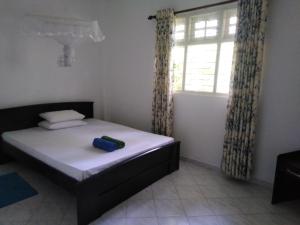 a small bedroom with a bed and a window at Anusha Apartment 15 Homestay in Galle