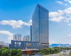 un grand bâtiment en verre en face d'une ville dans l'établissement Wanda Vista Changsha, à Changsha