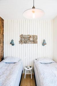 a bedroom with two beds and a white wall at Akurgerði Guesthouse 6 - Country Life Style in Ölfus