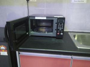 a microwave sitting on top of a kitchen counter at NAUFAL MUSLIM'S HOMESTAY in Cameron Highlands +21 photos