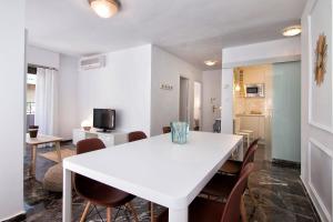 グラナダにあるtuGuest Aben Humeya Apartmentの白いダイニングルーム(白いテーブルと椅子付)