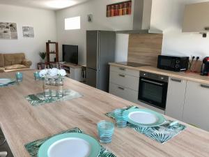 a kitchen with a wooden table with plates on it at Appartement 80m2 dans Villa in Propriano