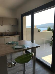 a kitchen with a table and a view of the ocean at Appartement 80m2 dans Villa in Propriano