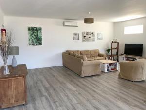a living room with a couch and a tv at Appartement 80m2 dans Villa in Propriano