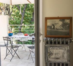 a patio with a table and a picture on the wall at BB CÀ DE MÂ in Pietra Ligure