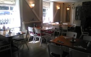 a restaurant with tables and chairs in a room at The Boathouse in Sutton Bridge