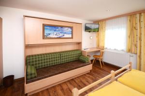 salon z zieloną kanapą i biurkiem w obiekcie Ferienhof Wölflbauer w Saalbach Hinterglemm
