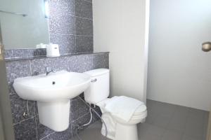 ナイヤンビーチにあるDOS'S HOUSEの白いトイレと洗面台のあるバスルーム