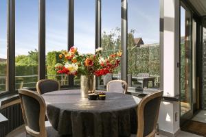 una mesa en una habitación con un jarrón de flores en Puur B&B en Amberes