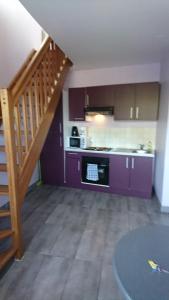 a kitchen with purple cabinets and a staircase at Résidence Baie de Seine in Le Havre