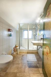 a bathroom with a tub and a toilet and a sink at Gästehaus Enzianhof Hotel Garni in Oberammergau