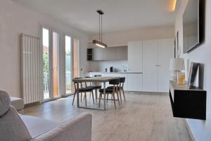 een keuken en een woonkamer met een tafel en stoelen bij Green Garda Desenzano in Desenzano del Garda