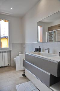 a bathroom with a sink and a toilet and a mirror at Green Garda Desenzano in Desenzano del Garda