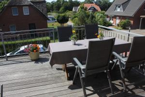 a table and chairs on a wooden deck at Ferienwohnung Wansiedler in Sankt Peter-Ording