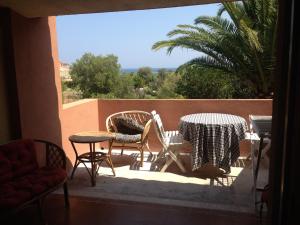 un patio con 2 mesas y sillas en un balcón en Cala d'Ambra e Ogliastra en San Teodoro