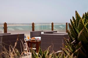 una mesa y sillas con vistas al océano en Villa De L'Ô, en Essaouira