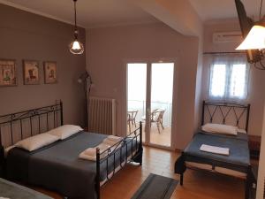 a bedroom with two beds and a balcony at Exarchos Guest House in Ioannina