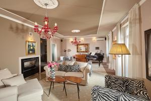 una sala de estar con muebles blancos y una lámpara de araña. en Karavla Private Villa, en Šentilj