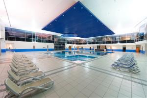 a swimming pool with lounge chairs in a building at Grand Hotel Konya in Konya