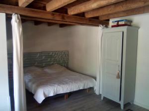 a bed in a room with a wooden ceiling at 21 Les Boissières in Saint-Branchs