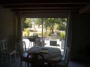einen Tisch und Stühle auf einer Terrasse mit einem Fenster in der Unterkunft 21 Les Boissières in Saint-Branchs