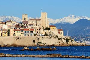 un groupe de bâtiments sur une colline avec des montagnes en arrière-plan dans l'établissement Bijou Apartment in Safranier - Old Town Antibes, à Antibes