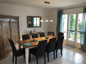 Casa al Castagno في Gambarogno: غرفة طعام مع طاولة خشبية وكراسي سوداء