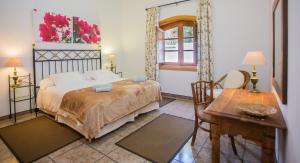 sypialnia z łóżkiem, stołem i biurkiem w obiekcie Finca de la Geria w mieście Yaiza