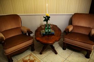 dos sillas y una mesa con un jarrón de flores en Pałac Jabłonowo en Ujście