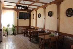 a restaurant with wooden tables and chairs and a screen at Zolota Pidkova in Kovel