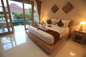 a bedroom with a bed with two birds on it at Uma Dhari Villa by Prasi in Ubud