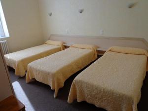Giường trong phòng chung tại Hôtel Hélios