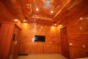 a room with a wooden wall with a flat screen tv at Sky Hotel in Phong Nha