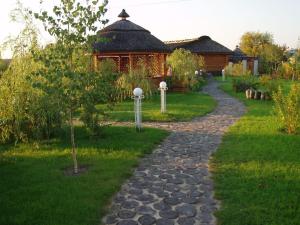 einen Steinweg, der zu einem Haus mit einem Gebäude führt in der Unterkunft Knyazhyi Dvir in Knyazhichi