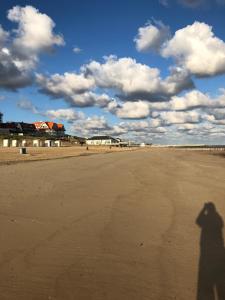 ein Schatten einer Person, die am Strand steht in der Unterkunft Familie beachhuis op de duinen (Duinhuis) in Cadzand