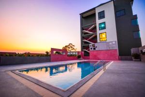 a swimming pool in front of a building at Comet Hotel Surat Thani in Suratthani