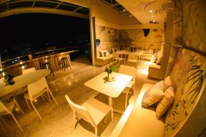 a living room with tables and chairs and a fireplace at Comet Hotel Surat Thani in Surat Thani