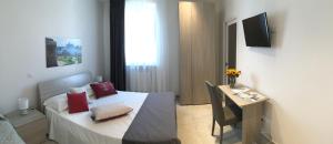 a small room with a bed and a table in it at Quattro Stelle al Porto Guest House in Civitavecchia