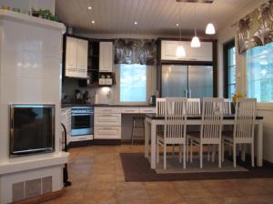 a kitchen with a table and chairs and a tv at Kohtalo Travel Villa - Rautalampi in Hankamäki