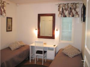 a bedroom with two beds and a desk and a mirror at Kohtalo Travel Villa - Rautalampi in Hankamäki
