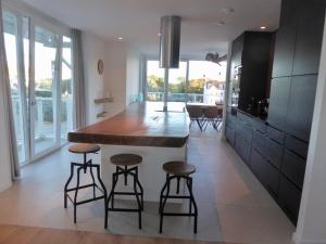 a kitchen with a large kitchen island with bar stools at Familie beachhuis op de duinen (Duinhuis) in Cadzand