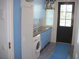 a kitchen with a washing machine and a washer at Kohtalo Travel Villa - Rautalampi in Hankamäki