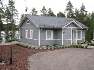 a small grey house with a gravel driveway at Kohtalo Travel Villa - Rautalampi in Hankamäki