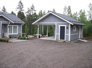 a home with a garage and a driveway at Kohtalo Travel Villa - Rautalampi in Hankamäki +9 photos