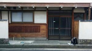 una porta per un edificio con uno zaino seduto fuori di Guesthouse Angoso a Niigata