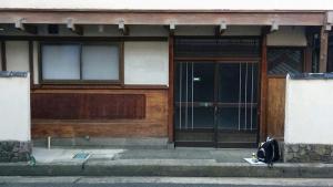 新潟市にあるゲストハウス　アンゴ荘の外に座るバックパック付きの建物への扉
